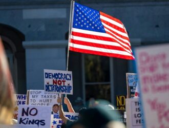 Protestors holding up signs at the No Kings protest
