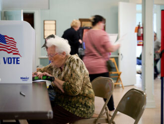 Elderly Woman casting her vote at polling location.