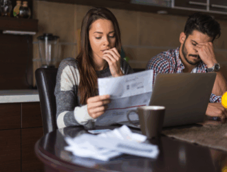 American couple looking at bills.