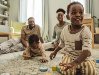 Happy African American family, enjoying time on living room floor.